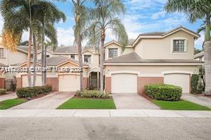3903 Tree Top Drive Weston, FL 33332 - Photo 1 of 18 a front view of a house with a garden and palm trees