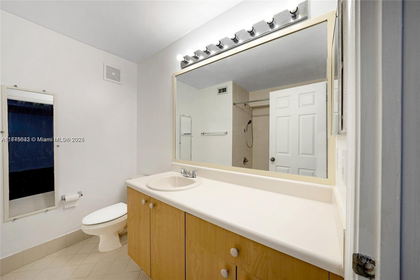 3903 Tree Top Drive Weston, FL 33332 - Photo 11 of 18 a bathroom with a toilet a sink and a mirror