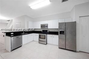 3903 Tree Top Drive Weston, FL 33332 - Photo 3 of 18 a kitchen with granite countertop stainless steel appliances and white cabinets