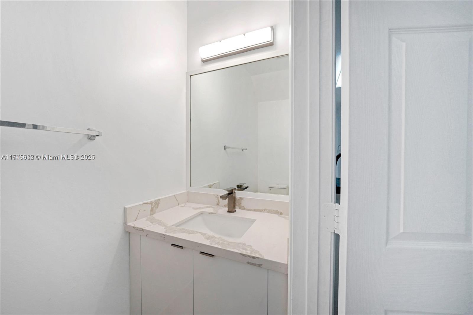 3903 Tree Top Drive Weston, FL 33332 - Photo 5 of 18 a bathroom with a sink and a mirror