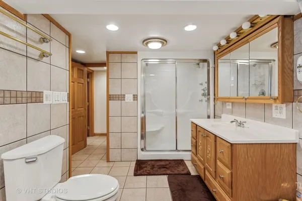 a bathroom with a sink a toilet a mirror and shower