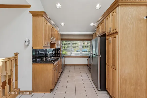 a kitchen with a sink a refrigerator and cabinets