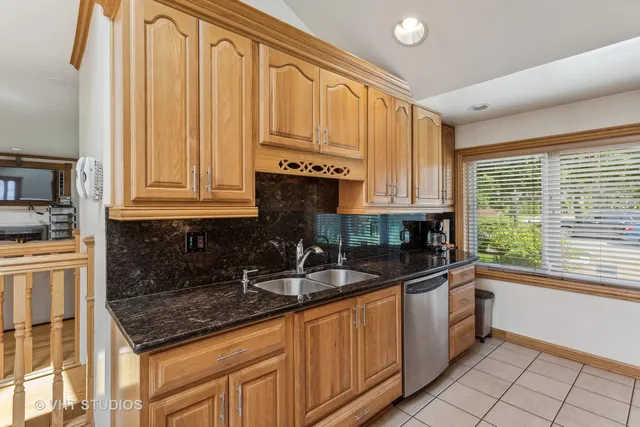a kitchen with stainless steel appliances granite countertop a sink a stove and cabinets