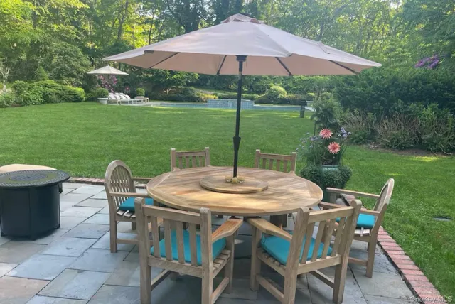 a patio with a table and chairs under an umbrella
