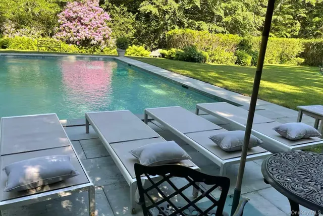 a view of a patio with lawn chairs next to a yard