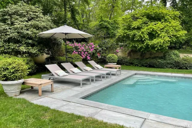 a view of a patio with furniture and a garden