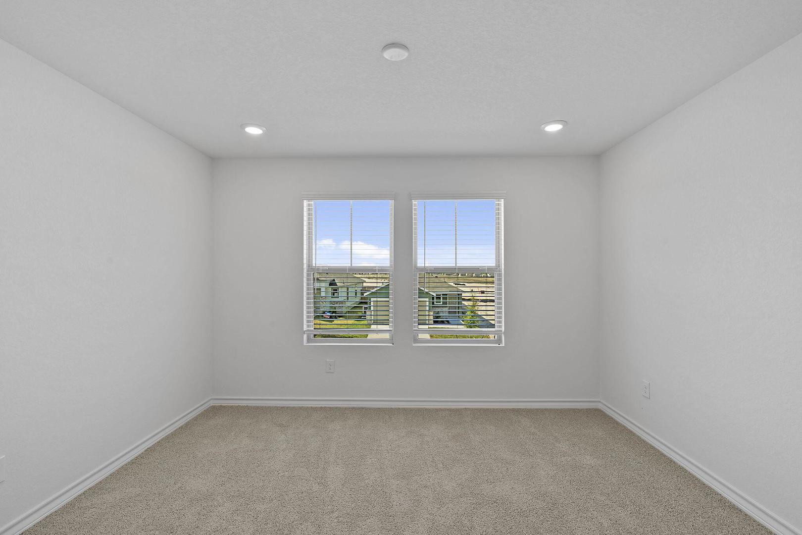 109 Hatari Trail Jarrell, TX 76537 - Photo 22 of 31 A well-lit bedroom features plush carpeting and broad windows.