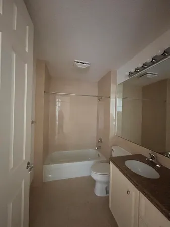 a bathroom with a granite countertop sink a toilet and shower