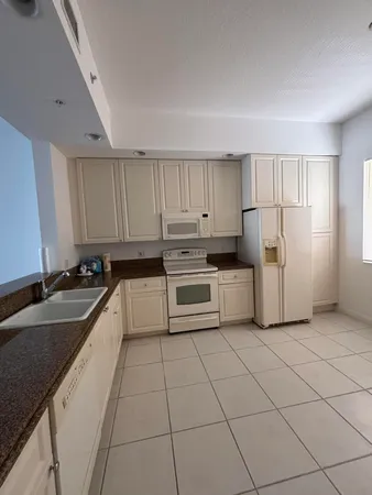 a kitchen with cabinets and white stainless steel appliances