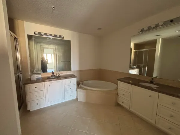 a spacious bathroom with a granite countertop sink mirror and bathtub