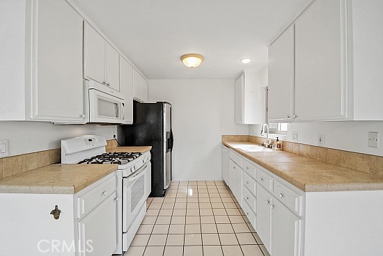 105 Alameda, Unit A San Clemente, CA 92672 - Photo 5 of 7 a kitchen with stainless steel appliances granite countertop a sink stove and refrigerator