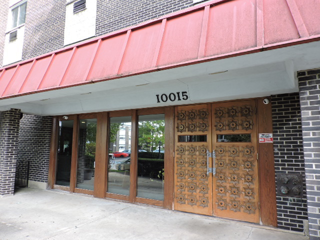 a front view of a building with glass door and an entrance