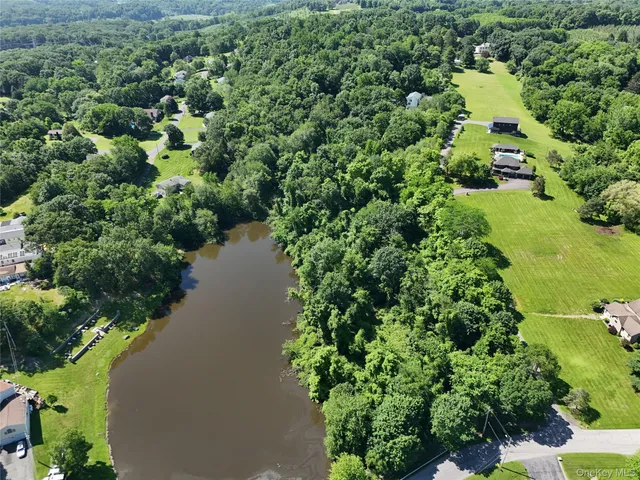 an aerial view of a house with a yard and lake view