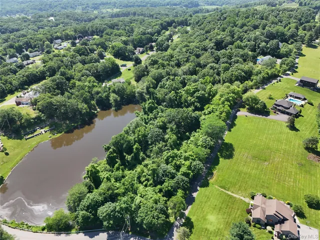 an aerial view of a houses with a yard and lake view