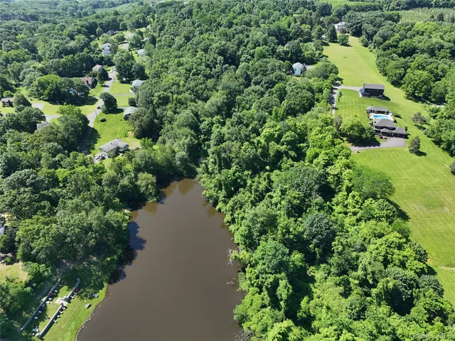 an aerial view of residential house with outdoor space and trees all around