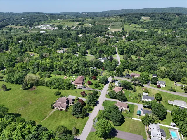 an aerial view of residential houses with outdoor space and trees