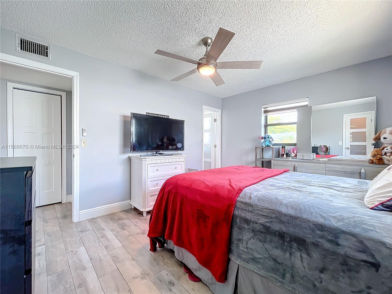 10324 Sleepy Brook Way Boca Raton, FL 33428 - Photo 14 of 29 a spacious bedroom with a bed and a flat screen tv