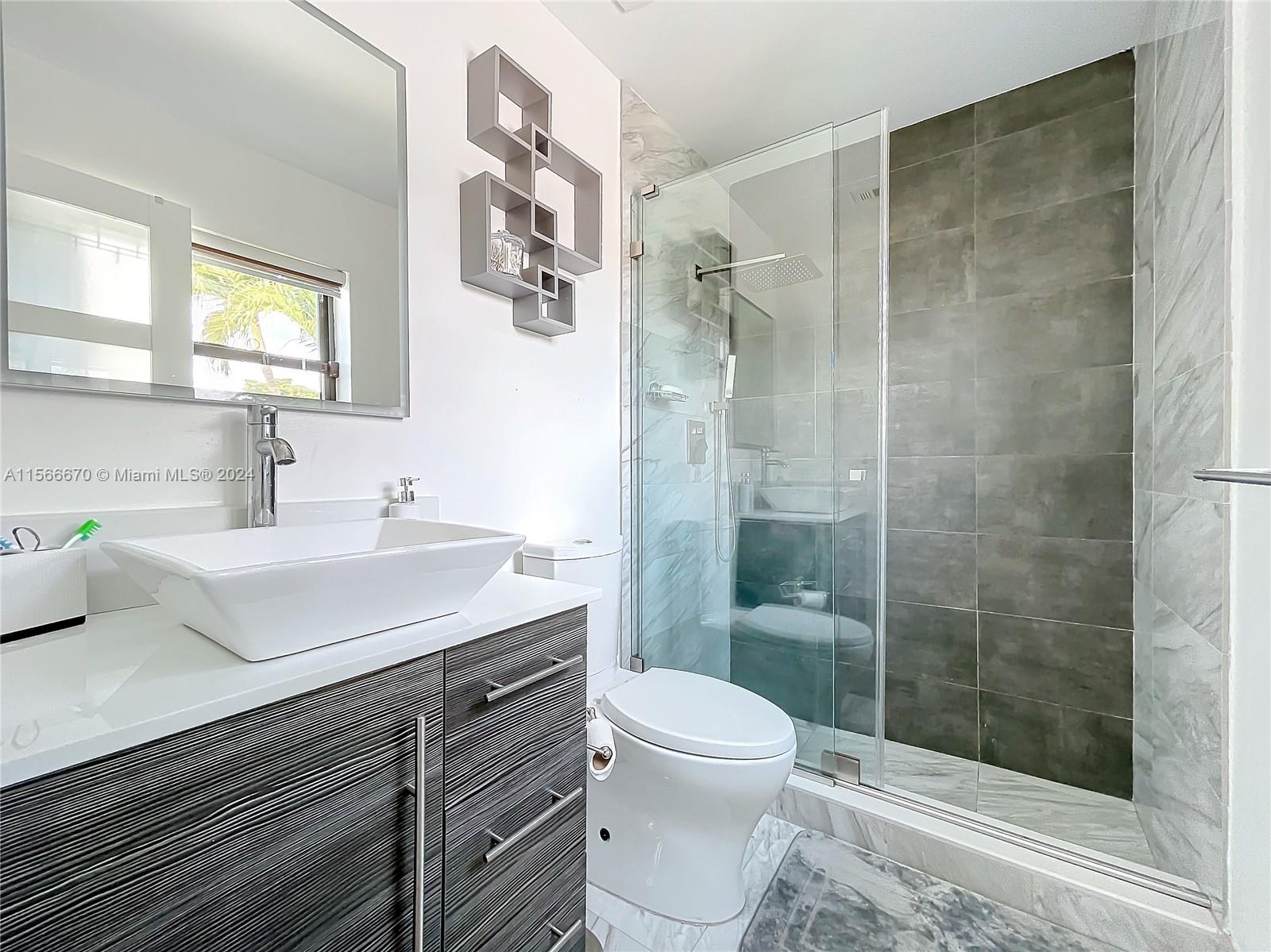 10324 Sleepy Brook Way Boca Raton, FL 33428 - Photo 15 of 29 a bathroom with a sink a toilet and shower