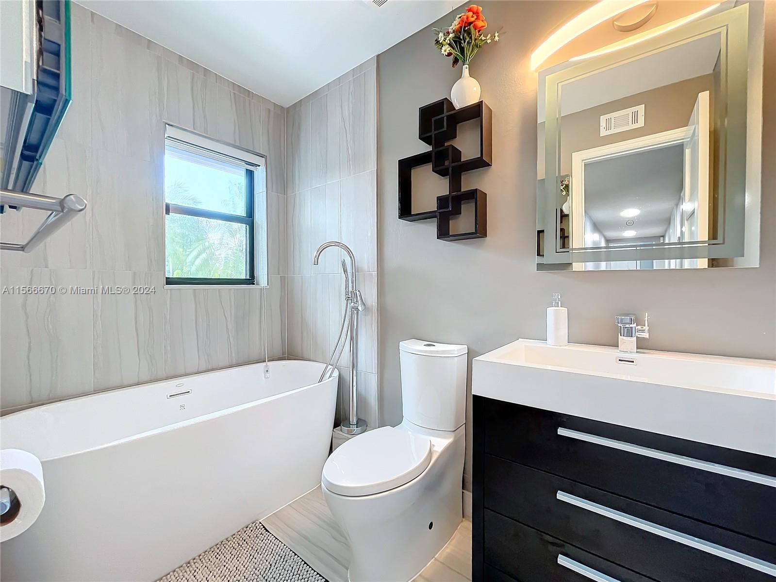 10324 Sleepy Brook Way Boca Raton, FL 33428 - Photo 18 of 29 a bathroom with a sink a toilet and a bathtub
