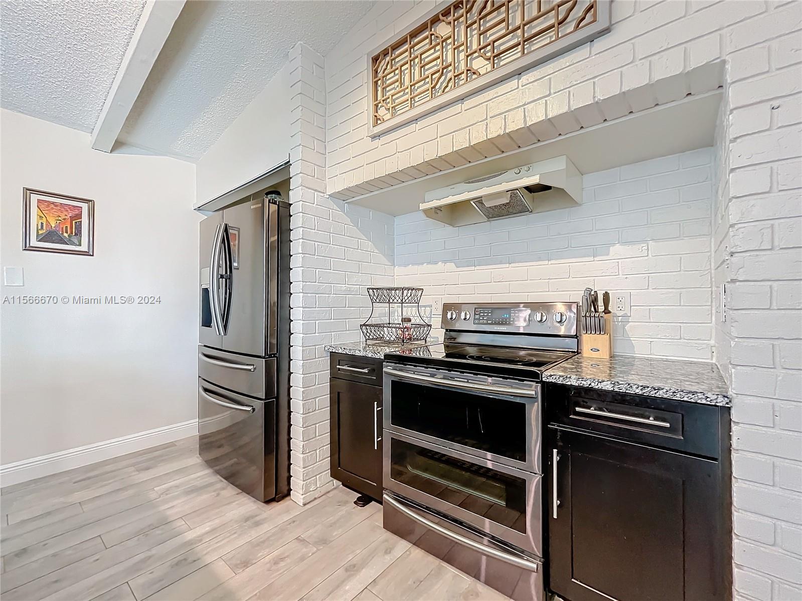10324 Sleepy Brook Way Boca Raton, FL 33428 - Photo 7 of 29 a kitchen with wooden floor and a stove top oven