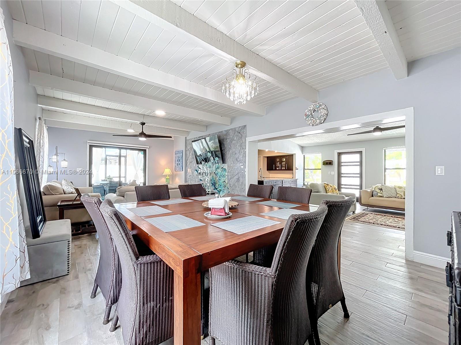 10324 Sleepy Brook Way Boca Raton, FL 33428 - Photo 10 of 29 a dining room with wooden floor a chandelier a wooden table and chairs