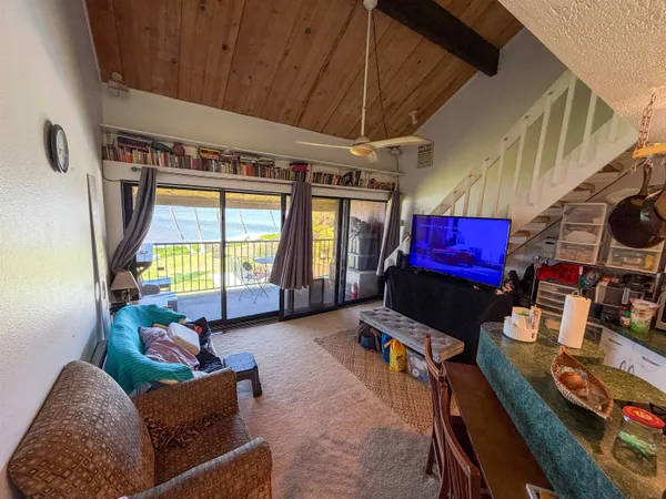 a living room with furniture a flat screen tv and a window