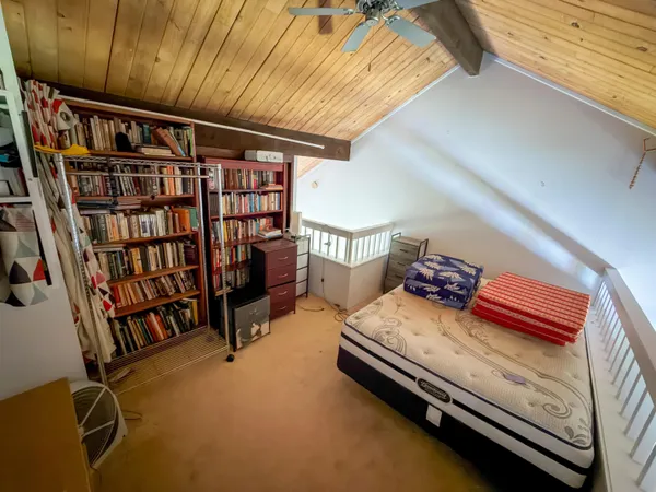 a bedroom with furniture and a book shelf