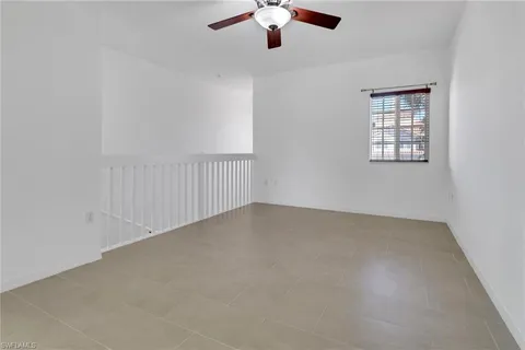 a view of an empty room with a chandelier fan