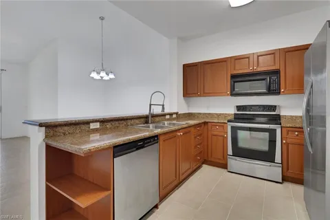 a kitchen with granite countertop a refrigerator and a sink