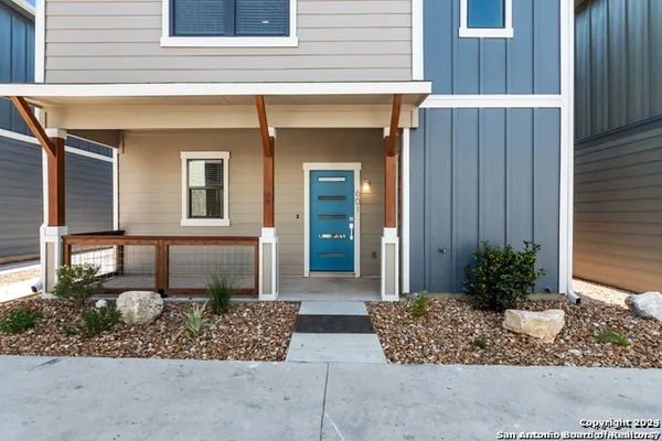 a view of house with potted plant and covered with wooden fence