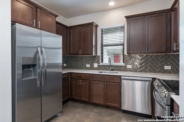 a kitchen with stainless steel appliances granite countertop a refrigerator and a sink