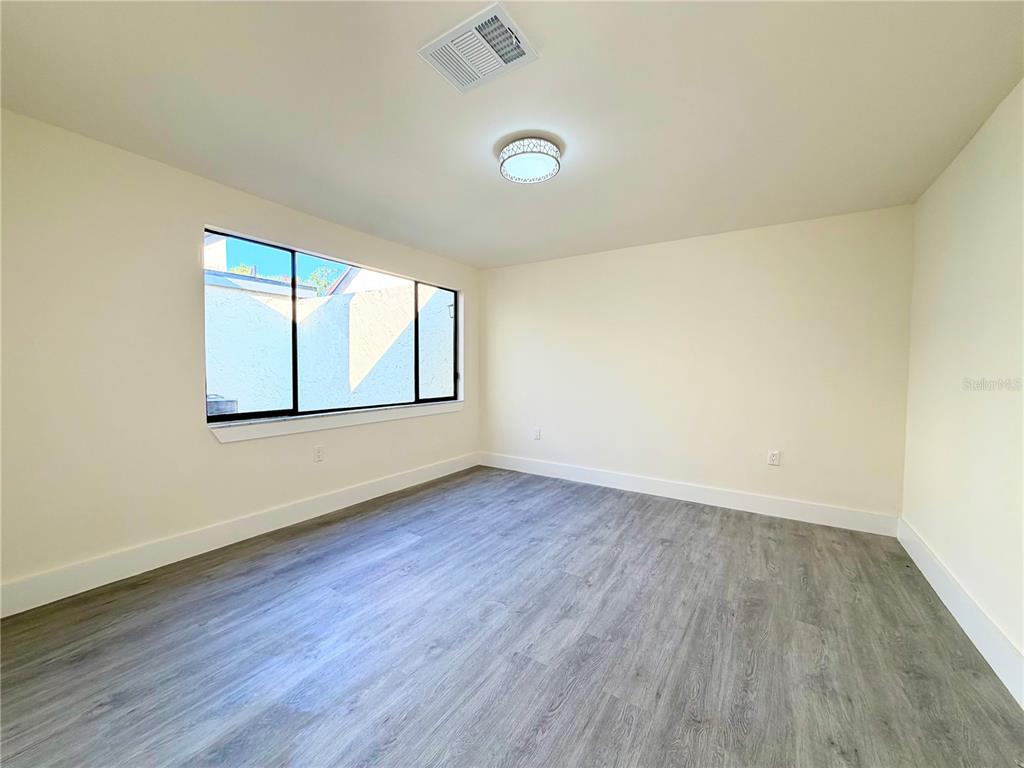 7314 Patio Row Hudson, FL 34667 - Photo 14 of 17 an empty room with wooden floor and windows