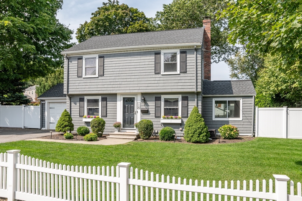 a front view of a house with a garden and plants