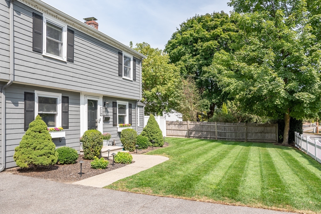 53 Bacon Street Natick, MA 01760 - Photo 3 of 30 a front view of a house with a yard and table and chairs