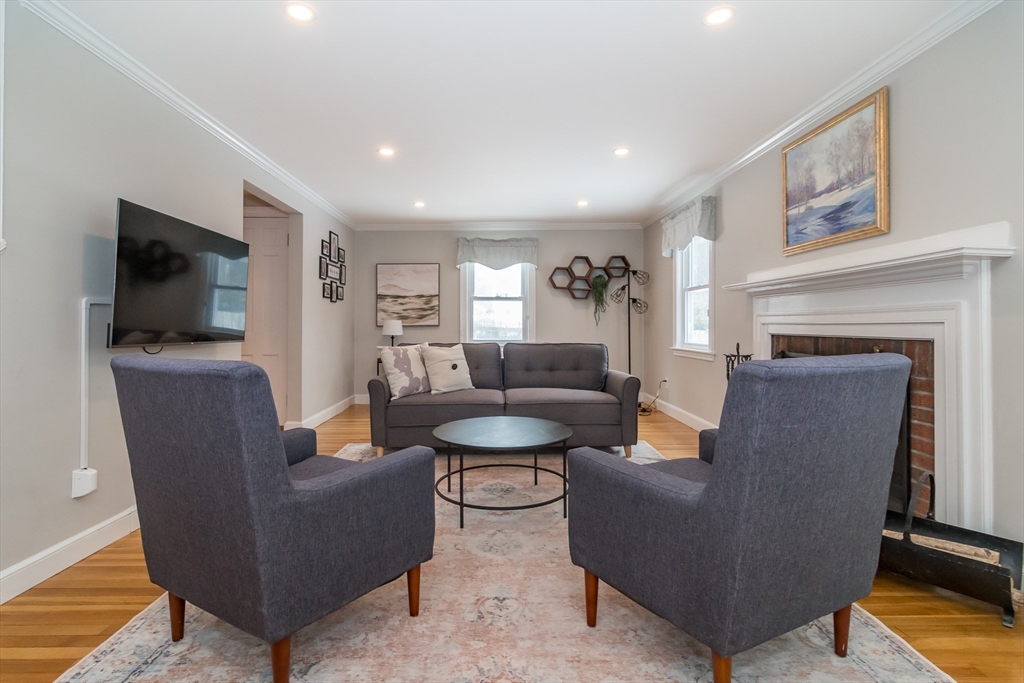 53 Bacon Street Natick, MA 01760 - Photo 6 of 30 a living room with furniture a flat screen tv and a fireplace