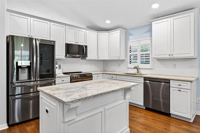 an aerial view of residential houses with outdoor space and trees all around