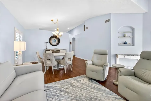 a dining room with furniture a chandelier and wooden floor