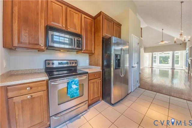 a kitchen with stainless steel appliances granite countertop a refrigerator a stove and a sink with granite countertops