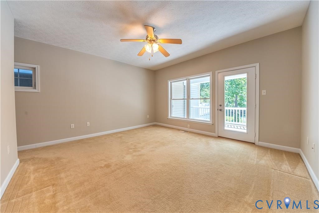 330 Chesapeake Watch Road, Unit 10B Deltaville, VA 23043 - Photo 14 of 48 an empty room with windows and chandelier fan