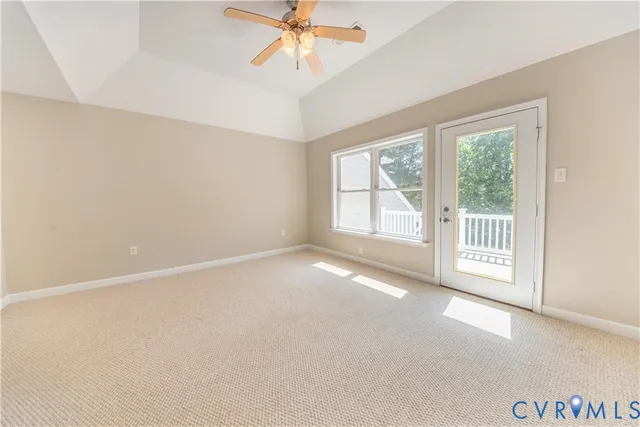 an empty room with windows and chandelier fan