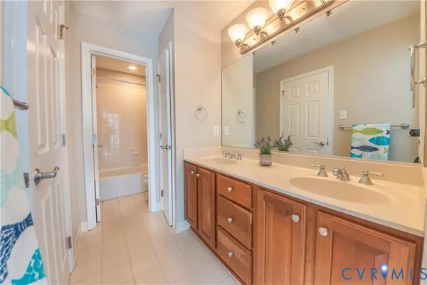 a spacious bathroom with a double vanity sink a large mirror a shower and a bathtub