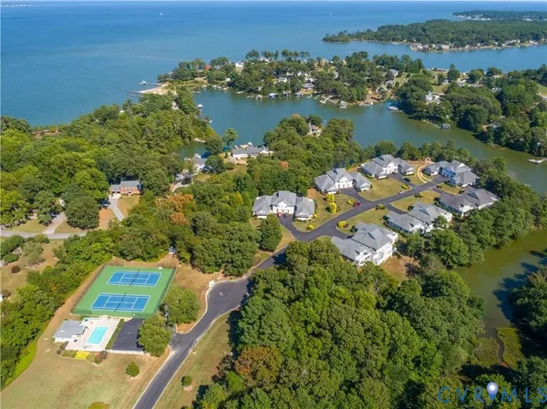 an aerial view of lake residential house with outdoor space and trees all around