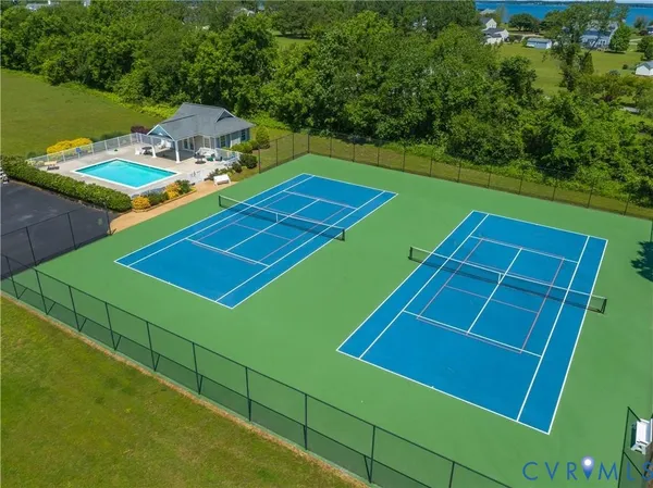 a view of a tennis ground with large trees