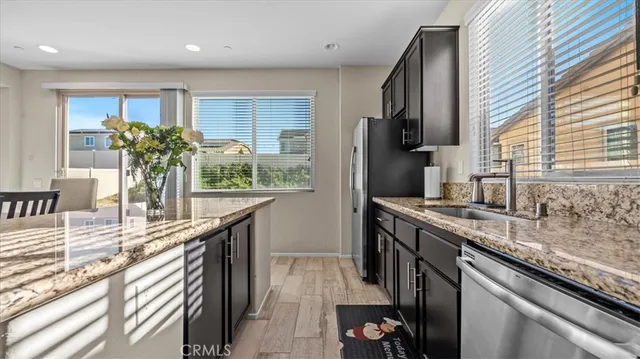 a kitchen with stainless steel appliances granite countertop a sink a stove and a refrigerator