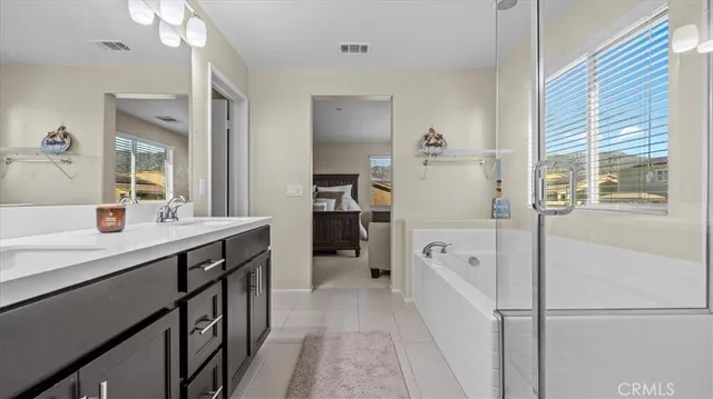 a en suite bathroom with a double vanity sink a mirror and a shower