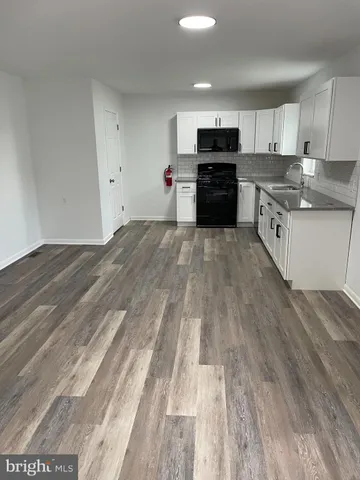 a kitchen with granite countertop a refrigerator and a stove top oven