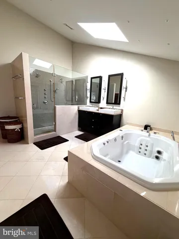 a bathroom with a tub sink and mirror