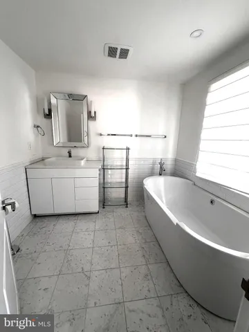 a bathroom with a bathtub and mirror