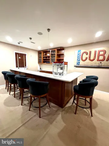 a living room with furniture a table and kitchen view