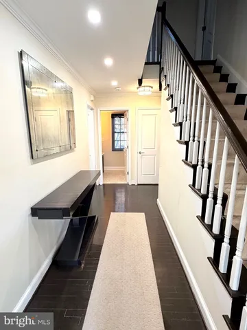 a view of a hallway with wooden floor and staircase